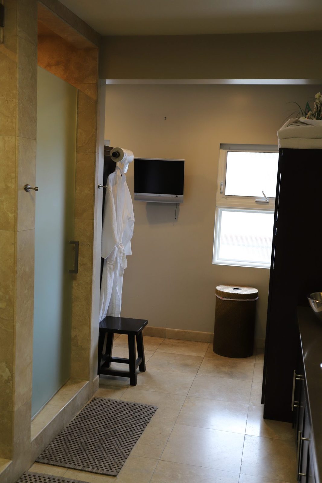 Her locker room at Executive Fitness — spa-style space with soaking area, robes, and stone tile